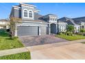Two-story house with a three-car garage and brick driveway at 4408 Renly Ln, Clermont, FL 34711