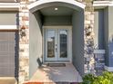 Elegant double front doors with arched entryway and stone accents at 4408 Renly Ln, Clermont, FL 34711