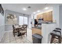 Kitchen with light wood cabinets, a granite countertop, and a dining area at 7606 Acklins Rd, Kissimmee, FL 34747