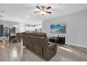 Open living room and kitchen with tile floors and brown couches at 1917 Michigan Drive, Poinciana, FL 34759
