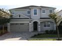 Two-story house with gray siding, a three-car garage, and landscaping at 289 Auburn Ave, Kissimmee, FL 34747
