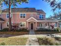 Pink two-story townhome with front porch and landscaping at 3383 Westchester Square Blvd # 202, Orlando, FL 32835