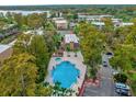 Aerial view of community pool, clubhouse, and surrounding landscape at 3995 Versailles Dr # 3995F, Orlando, FL 32808