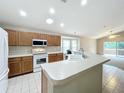 Kitchen boasts wood cabinets, white appliances, and an island at 425 Tree Shore Dr, Orlando, FL 32825