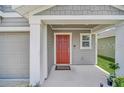 Red front door entryway with a covered porch and gray siding at 4382 Sunny Creek Pl, Kissimmee, FL 34746