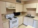 White appliances and light wood cabinets in this galley style kitchen at 485 Forestway Cir # 202, Altamonte Springs, FL 32701