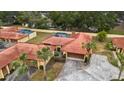 Aerial view showcasing a community of homes with red tile roofs and lush greenery at 5027 Jamaica Cir # 7, Orlando, FL 32808