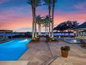 Luxury backyard oasis with pool, spa, and waterfront views at sunset at 100 Blue Lake Ct, Longwood, FL 32779