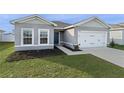 Gray house with white garage door and dark blue front door at 1224 Golden Eagle Ln, Winter Haven, FL 33880