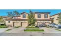 Three townhouses side by side, two-car garages, and a tree at 8169 Roseville Rd, Davenport, FL 33896