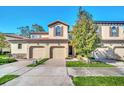 Two-story townhome with two-car garage and a tree in front at 8169 Roseville Rd, Davenport, FL 33896