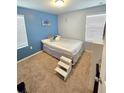 Bright bedroom featuring a blue accent wall and plush carpeting at 604 Madison Dr, Davenport, FL 33837