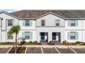 Two-story townhome with light gray siding, blue shutters, and a two-car driveway at 7420 Oakmoss Loop, Davenport, FL 33837