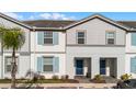 Front view of a two-story townhome with gray siding and blue shutters at 7420 Oakmoss Loop, Davenport, FL 33837