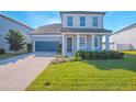 Inviting front yard with a well-maintained lawn, a driveway leading to a two-car garage, and a covered entryway at 840 Livestock Loop, St Cloud, FL 34771