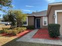 Front entry of a house with a dark-colored door and red mulch landscaping at 146 Prairie Falcon Dr, Groveland, FL 34736