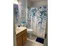 Clean bathroom with shower/tub combo and floral shower curtain at 209 Curtis Ave, Groveland, FL 34736