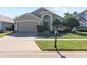 Two-story house with a green exterior, two-car garage, and a well-maintained lawn at 422 Troon Cir, Davenport, FL 33897