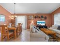 Combined living and dining area with light beige colored sofa and wooden dining table at 422 Troon Cir, Davenport, FL 33897