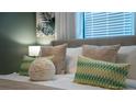 Close-up view of bedspread with patterned pillows and a white fluffy ball at 4322 Lana Ave, Davenport, FL 33897