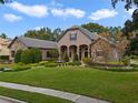 Beautiful home with stone and stucco exterior, manicured lawn, and mature trees at 25510 High Hampton Cir, Sorrento, FL 32776