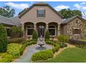 Inviting front yard with a stone fountain, lush landscaping, and a charming walkway at 25510 High Hampton Cir, Sorrento, FL 32776