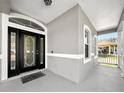 Elegant front entrance with a black door and glass accents at 1022 Whirlaway Dr, Kissimmee, FL 34744