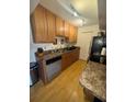Efficient kitchen with light wood cabinets, stainless steel appliances, and laminate flooring at 2810 Plaza Terrace Dr # 2810, Orlando, FL 32803