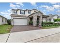 Two-story house with a white garage door and stone facade at 443 Dancing Water Dr, Winter Springs, FL 32708