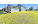 Large grassy backyard with a view of the house and garage at 12285 Joshua Tree Trl, Windermere, FL 34786