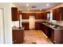 Kitchen with brown wood cabinets, granite countertops, and tiled floor at 15443 Perdido Dr, Orlando, FL 32828