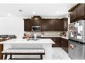 Open-concept kitchen with dark wood cabinets, a large island, and stainless steel appliances at 2097 Celebration Blvd, Celebration, FL 34747