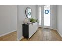 Bright entryway with wood-look floors and a modern console table at 3359 Hanging Tide St, Winter Garden, FL 34787
