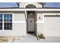 Close-up view of the home's entrance, featuring a charming front door and attached garage at 111 Windy Dune Ct, Kissimmee, FL 34743