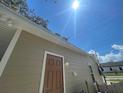 Side view of tan house with brown door and gutters at 1170 S Central Ave, Apopka, FL 32703