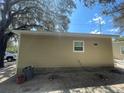 Rear view of tan house with a trash can and yard at 1170 S Central Ave, Apopka, FL 32703