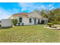 Tan house with gray garage door and a nicely landscaped front yard at 1812 Hudson Ct, Kissimmee, FL 34759