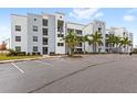 Modern apartment building with ample parking and palm trees at 4721 Clock Tower Dr # 204, Kissimmee, FL 34746