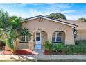 Tan house with a white door, palm trees, and red mulch at 505 Polaris Loop # 107, Casselberry, FL 32707