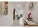 Inviting entryway with contemporary art, elegant console table, and view to living area at 8942 Cabot Cliffs Dr, Davenport, FL 33896
