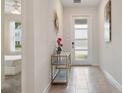 Bright foyer with modern decor, tile flooring, and view to a bedroom at 8942 Cabot Cliffs Dr, Davenport, FL 33896
