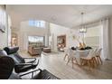 Open-concept living and dining area with high ceilings, large windows, and modern furniture at 8942 Cabot Cliffs Dr, Davenport, FL 33896