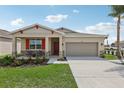 One-story house with orange accents, stone facade, and a two-car garage at 1104 Patriot Loop, Haines City, FL 33844