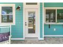 White front door with glass panels and black hardware, welcoming entryway at 12071 Lakeshore Way, Oxford, FL 34484