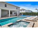 Luxury pool and spa with lounge chairs, outdoor kitchen, and basketball court at 165 Golden Noble St, Kissimmee, FL 34747