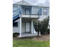 Exterior view of a two-story condo unit with a balcony and stairs at 2504 Woodgate Blvd # 107, Orlando, FL 32822