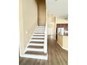 Modern staircase with a neutral color scheme and wood flooring at 4059 Longworth Loop, Kissimmee, FL 34744