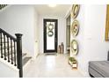 Bright entryway with tile flooring, staircase, and decorative mirrors at 5427 Hanover Square Dr, St Cloud, FL 34771