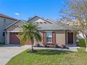 Tan house with brown accents, palm tree, and landscaped yard at 14638 Tullamore Loop, Winter Garden, FL 34787