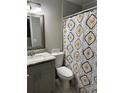 Well-appointed bathroom with a granite countertop vanity and a patterned shower curtain at 1704 Osceola Park Dr, Kissimmee, FL 34741
